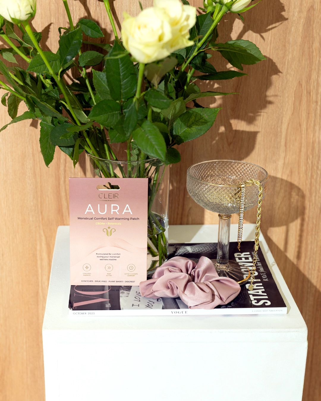 AURA Self-Warming Patch pack resting on a pink satin robe